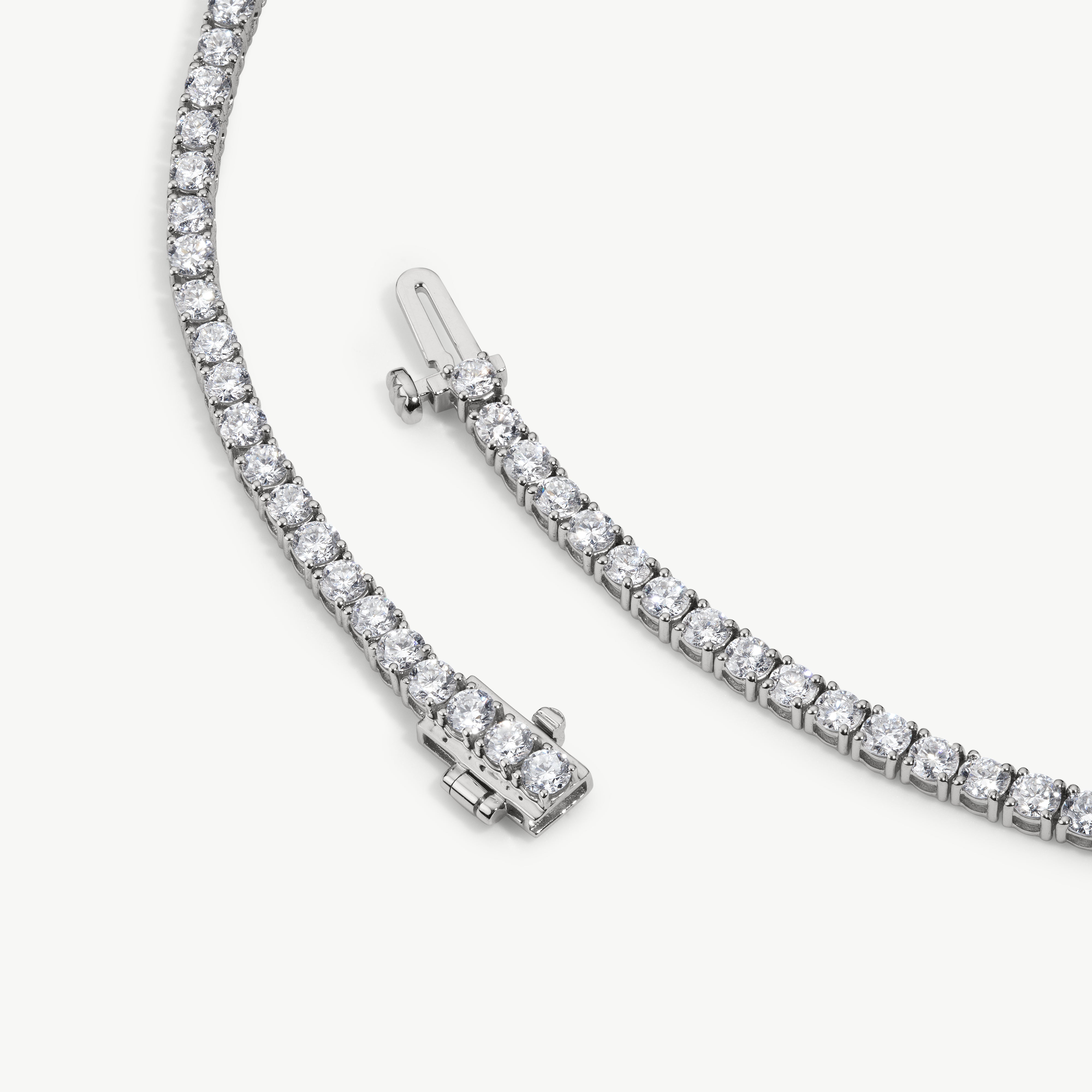 Round diamonds in polished, rounded gold tennis bracelet settings
